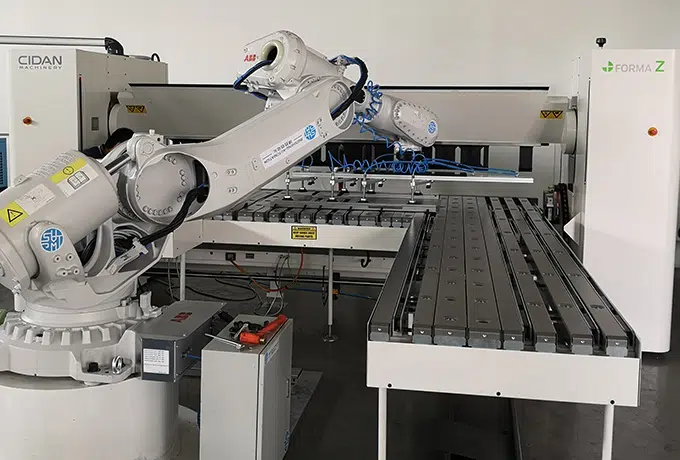folding machine served by a robot on white background