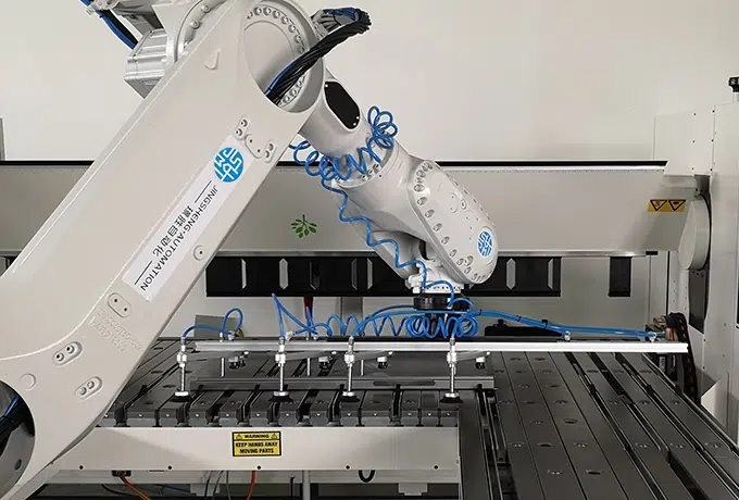 folding machine served by a robot on white background