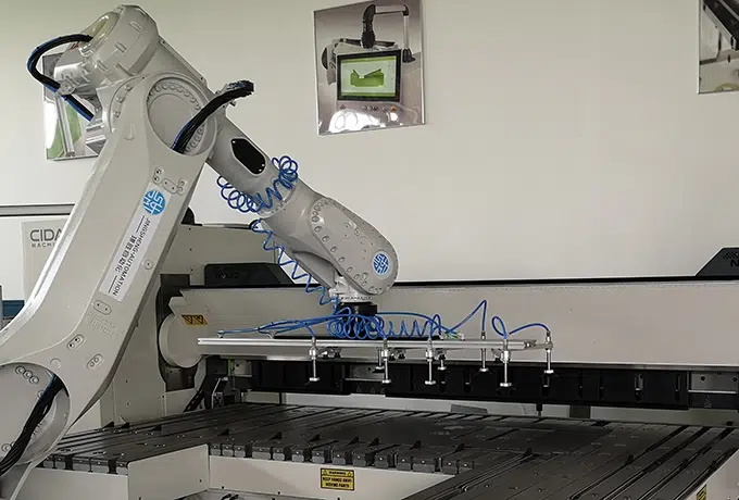 folding machine served by a robot on white background